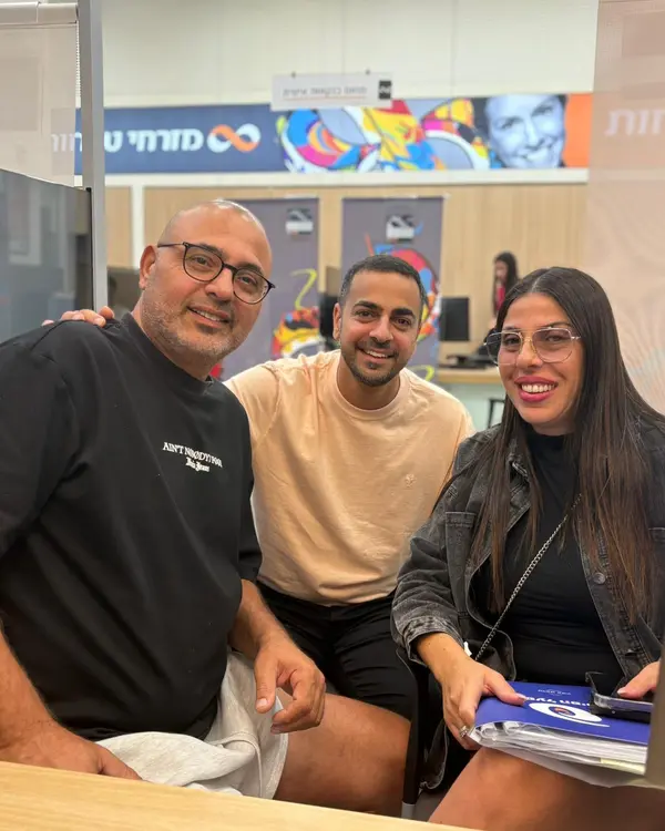 גלעד עם לקוחות ליד שולחן החתימות